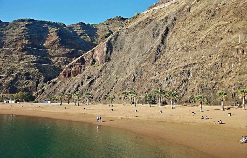 Vista de la playa de Las Teresitas en Tenerife con palmeras, arena dorada y costa de Anaga