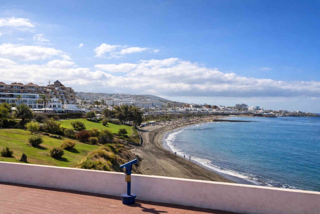 Costa Adeje Tenerife con su playa de arena negra y aguas cristalinas en un día soleado