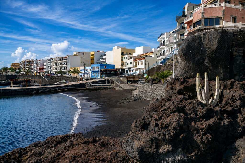 Playa y paseo marítimo de La Restinga, en El Hierro, con arena volcánica y casas junto al mar
